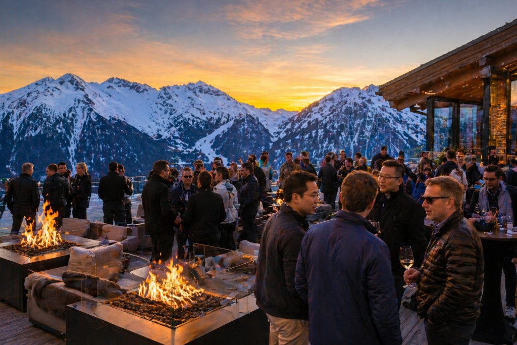 People talking around fire pits on a mountain terrace at sunset